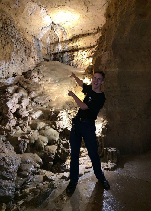 Photo of a tour guide pointing at some of our cave formations.